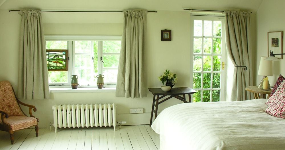 A country cottage bedroom with linen curtains