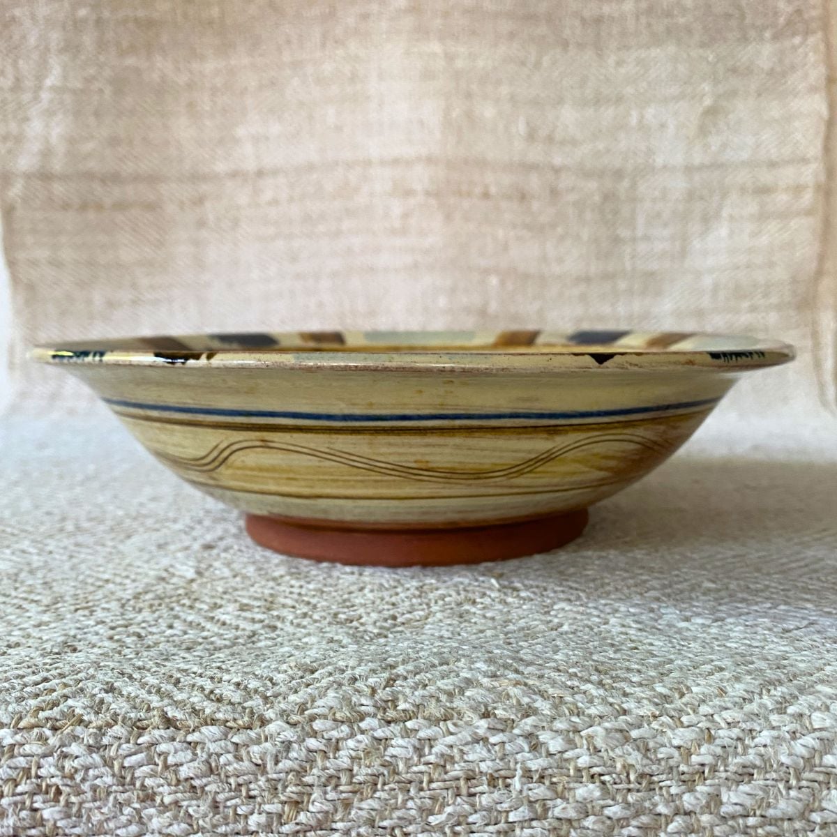 Jennifer Hall Slipware pasta bowl from the side on a cream textile background