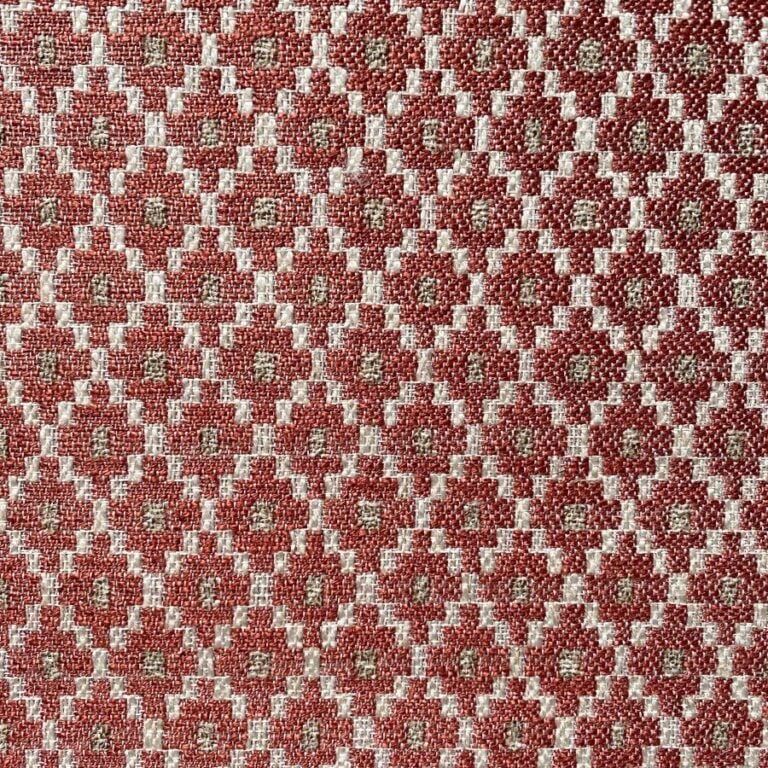 Brick red upholstery fabric with a small diamond shaped pattern in the weave