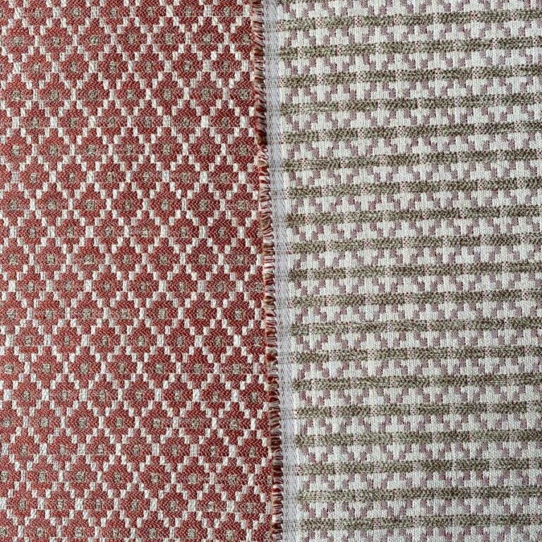 Brick red upholstery fabric with a small diamond shaped pattern in the weave